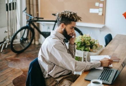 Man working at a desk and on the phone