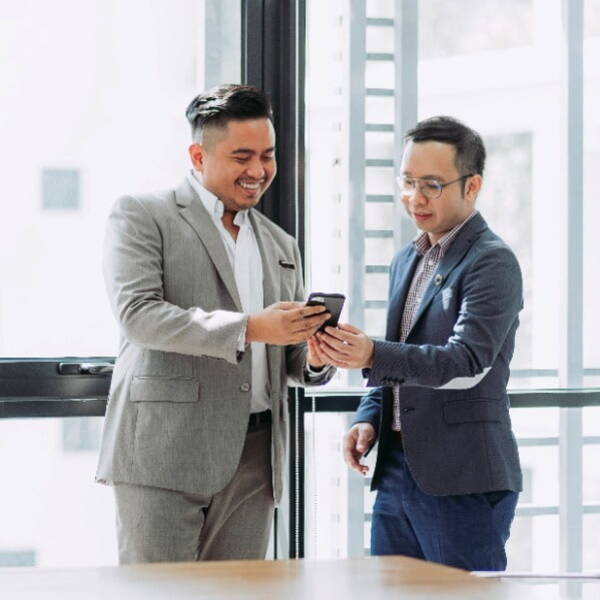 Two smiling people looking at a phone